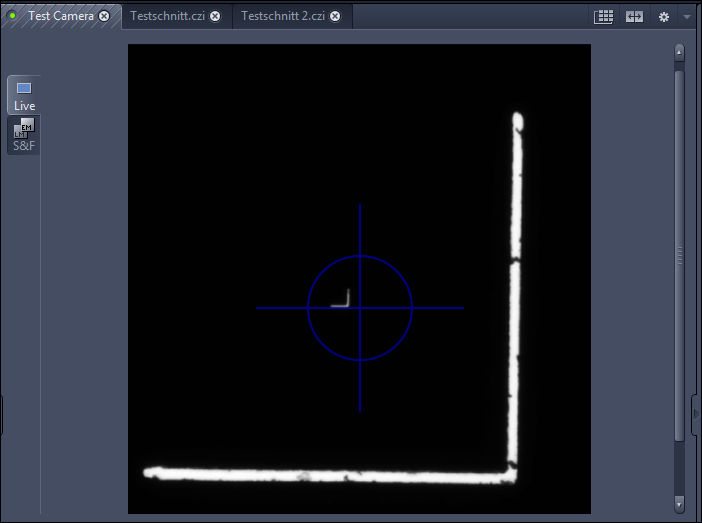Software view: bright L-shaped holder at bottom-right and small L-shaped marker at center with blue crosshair.