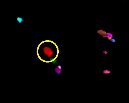 Black background with colored 3D blobs; yellow circle highlights a red blob touching a small green fragment.