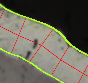 Close-up of layer cross-section with neon green edge overlays and red grid chords on a light sample.