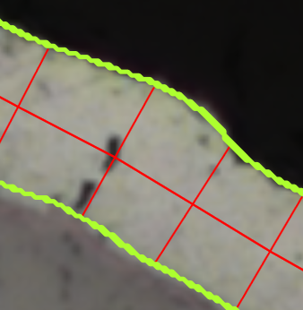 Close-up of layer edge with neon green overlay and red grid chords on pale sample against dark background.